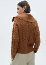 Sweater marrón de punto grueso trenzado con cuello polo amplio y mangas largas.