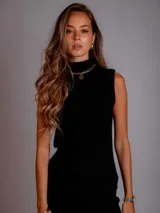 Conjunto tejido negro, compuesto por un chaleco corto sin mangas con cuello alto y un pantalón largo de corte ajustado.