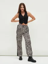 Pantalón de tiro alto con estampado animal print y corte palazzo. Presenta cintura elastizada con cordón ajustable y detalle de franja lateral negra.