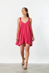 Vestido corto fucsia con breteles finos con volados y escote en V. Diseño holgado y corte evasé.