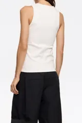 Top blanco de algodón con corte ajustado, cuello redondo y sisas anchas. Presenta un estampado de un cactus con abalorios y el logo de la marca.