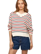 Sweater de punto color crema con rayas horizontales rojas y azul marino. Tiene cuello en V, mangas largas y logo de Tommy Hilfiger bordado en el pecho.