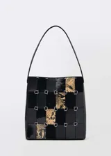 Bolso de hombro de cuero negro con diseño patchwork que combina diferentes texturas y estampados, incluyendo animal print.