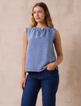Blusa celeste sin mangas en crepe con cuello a la base con frunce, apertura ojal y botón.
