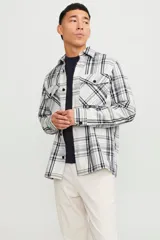 Sobrecamisa de manga larga en blanco y negro con diseño a cuadros, cierre con botones y bolsillos frontales.