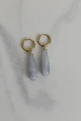 Par de aros colgantes con argolla dorada y dije en forma de gota de piedra natural color celeste.
