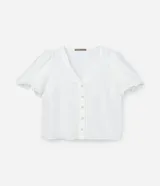 Blusa blanca de crepé con escote en V, abotonada en el frente y mangas cortas abullonadas.