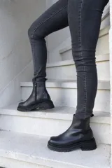 Botas de cuero negro con punta cuadrada, caña media y cierre lateral con cremallera.