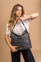 Cartera bandolera color marrón claro, de símil cuero, con dos divisiones internas, asa corta fija y correa larga regulable.