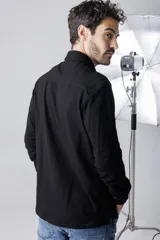 Camisa negra de piqué, corte clásico, con cuello abotonado y bolsillo en el pecho.