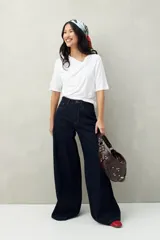 Remera de modal color marrón claro, de manga corta, con cuello asimétrico y detalle de nudo con frunces.