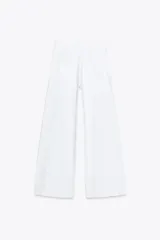 Pantalón de jean blanco, de tiro medio y corte wide leg, con cinco bolsillos y costuras laterales marcadas.