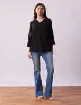 Blusa negra de gasa bambula con cuello a la base y escote en V. Tiene mangas 3/4 amplias con apliques de crochet.