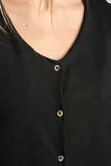 Blusa blanca con escote en V, mangas cortas con volados y cierre frontal con botones.