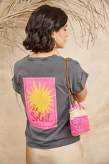 Remera gris de algodón con estampa en la espalda de un sol amarillo sobre un rectángulo fucsia con la inscripción "le Solei".