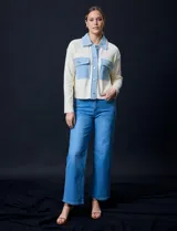 Campera combinada de punto color crema con detalles en denim celeste. Tiene cuello con solapa, cierre frontal con botones metálicos, bolsillos delanteros y corte recto.