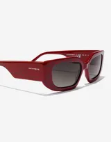 Lentes de sol Hawkers modelo Trendset, con montura rectangular de color rojo marmolado y lentes negras.