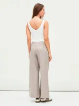 Pantalón de vestir color visón con finas rayas verticales, tiro alto y corte palazzo.