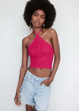 Top tejido al crochet color fucsia, con cuello halter y tirantes finos.