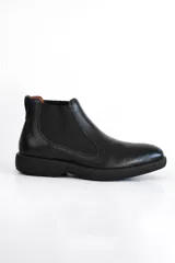 Bota Chelsea de cuero negro con elástico lateral y suela gruesa.