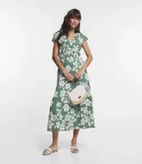 Vestido midi de viscolino con estampado de flores blancas y rayas verticales verdes. Tiene escote en V, mangas cortas amplias y cintura elástica.