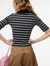 Top ajustado al cuerpo con cuello tipo polo, a rayas horizontales blancas y negras, con botones en el escote y mangas cortas.
