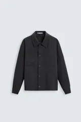 Sobrecamisa negra de corte amplio, con cuello solapa, manga larga con puños abotonados, bolsillos de parche en el pecho, bolsillos laterales y cierre frontal con botones.