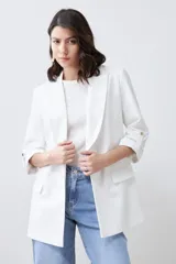 Blazer color crudo de corte recto, con cuello solapa, mangas 3/4 con botón y bolsillos frontales.