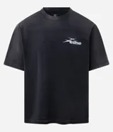 Remera negra de algodón con efecto desteñido (stone wash), corte boxy y manga corta. Estampa grande en la espalda con cinco calaveras amarillas y texto en blanco que dice "SAVAGE SQUAD" y debajo "WE WERE NEVER QUIET".