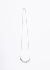 Collar de plata 925 con cadena forcé y una hilera de piedras de topacio celeste talladas en forma de gota, dispuestas en forma de arco.