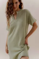 Vestido tejido color verde claro, con escote en V, mangas cortas y aberturas laterales.