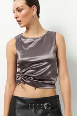 Musculosa negra de satén con cuello redondo y cordón ajustable en el lateral izquierdo para fruncir la prenda.