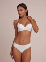 Colaless blanca de algodón con detalle de puntilla en la cintura y moño decorativo.