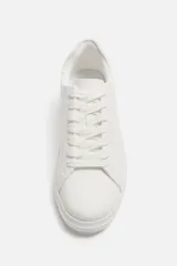 Zapatillas deportivas blancas, de estilo minimalista, con cordones y suela gruesa.