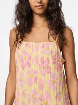 Vestido largo de tirantes finos con estampado floral rosa sobre fondo amarillo, corte recto y escote cuadrado.