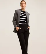 Pantalón zanahoria de sastrería color blanco, con cintura alta, trabillas y botón contrastante.