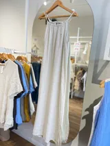 Vestido largo de lino color crudo, con escote halter fruncido y abertura lateral en la falda.