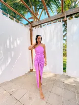 Vestido largo lila con escote halter cruzado en la espalda y falda tipo pareo con abertura lateral y nudo decorativo.