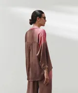 Camisa oversize color marrón con degradé rosado, cuello clásico, botones al frente, mangas largas con puños abotonados, canesú con frunces en la espalda y aberturas laterales.