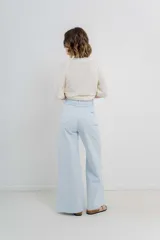 Pantalón de tiro alto, corte palazzo amplio y fluido, color celeste claro. Presenta bolsillos delanteros y traseros tipo jean, con logo metálico Peach en la parte posterior.