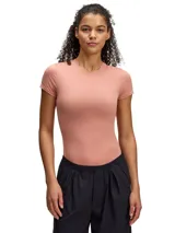 Remera deportiva color salmón, de corte ajustado y mangas cortas.