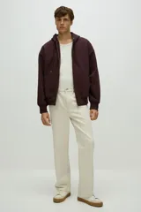 Campera con capucha y cierre frontal, color marrón oscuro (borgoña/vino), de tejido pesado con interior cepillado suave. Presenta hombros caídos, bolsillos delanteros tipo canguro divididos y puños y bajo acanalados.