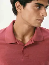 Camiseta tipo polo de manga corta, color azul oscuro, con cuello y tapeta de dos botones.