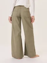 Pantalón ancho de algodón color verde militar, con corte holgado, pinzas debajo de la rodilla y pespuntes a contratono. Presenta un bordado de monograma en el bolsillo delantero.