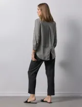 Camisa celeste de tencel con cuello con solapa, escote en V, abertura central con botones y mangas 3/4 regulables con presilla y botón.