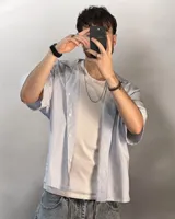 Camisa celeste y blanca a rayas verticales, de corte boxy fit y manga corta.