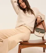 Pantalón marrón de jeans, corte wide leg cropped, con cintura media, trabillas, cierre con botón y cremallera, y bolsillos traseros.