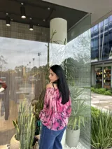 Blusa con hombros descubiertos, estampado floral en tonos rosados y mangas largas abullonadas.