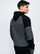 Campera con capucha Umbro de piqué, color gris con mangas negras y logo bordado en blanco.