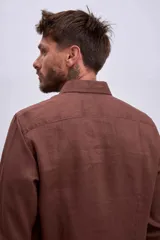 Camisa de lino color crudo, de corte recto, con cuello clásico y mangas largas.